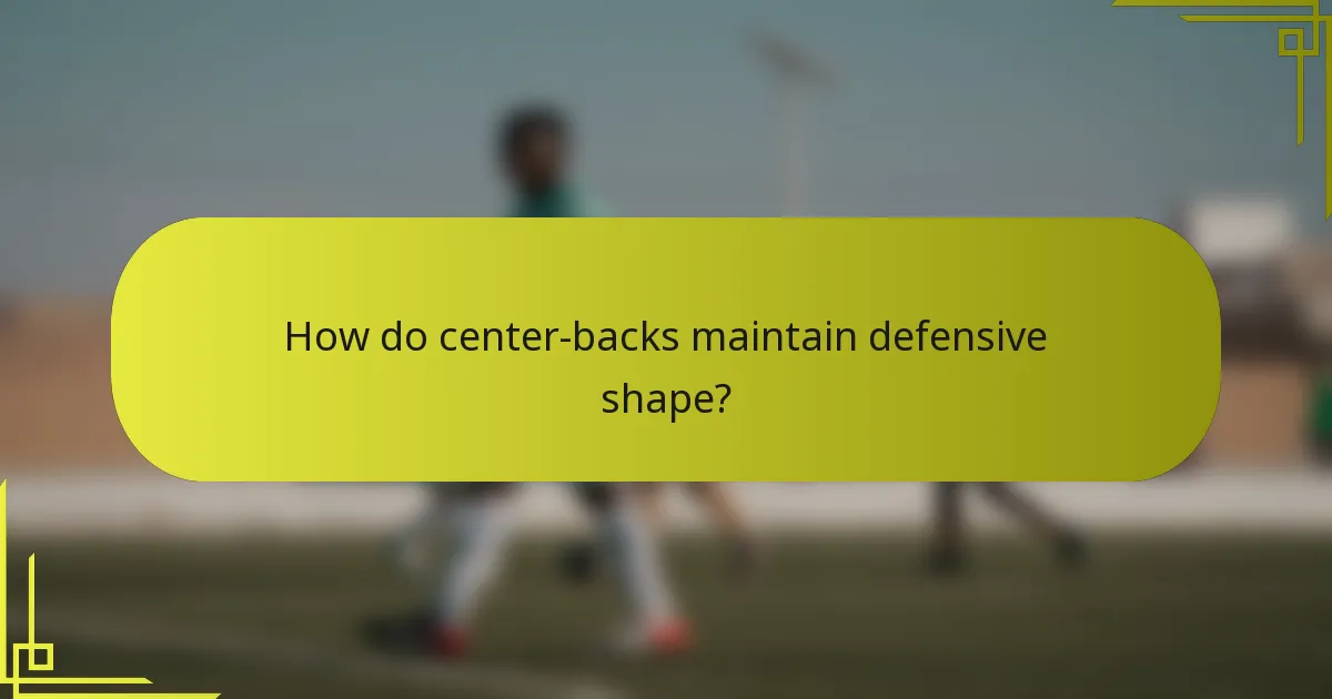 How do center-backs maintain defensive shape?